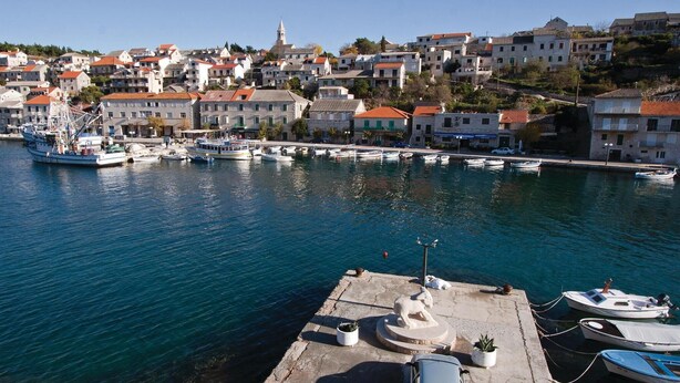 A coastal town with a marina, boats, and buildings with red roofs. - Cozy apartment in Povlja (Povlja)