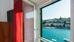 A room with a view of a harbor, including boats and buildings. - Cozy apartment in Povlja (Povlja)