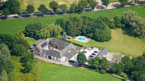 Ein Luftbild eines Wohngebiets mit einem großen Haus, einem Schwimmbad und einer Auffahrt.