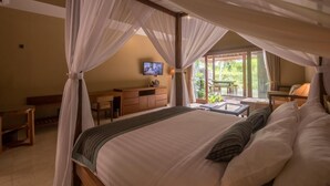 Quarto com cama de dossel, televisão na parede e vista para o exterior.