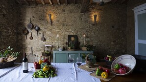 Una habitación rústica con paredes de piedra, vigas de madera y una mesa dispuesta con comida y vino.