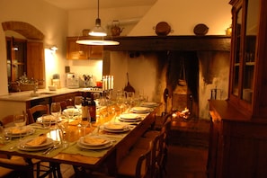 Enjoy meals in this cozy dining area with a traditional fireplace and wooden table.