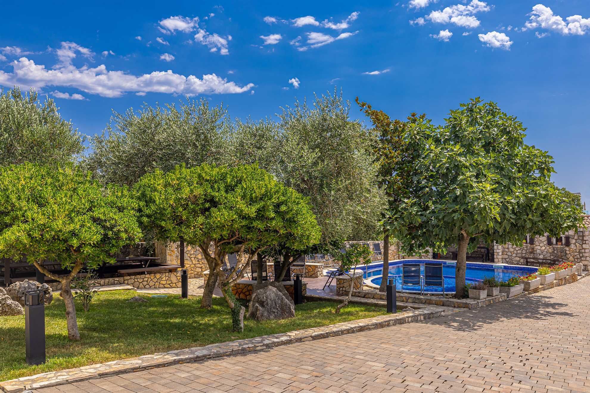 A pool area with stone walls and a clear blue sky.