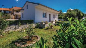 Ein modernes, zweistöckiges Haus mit einer Steinwand und einem gepflegten Garten.