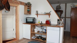 A compact kitchen with a microwave, toaster, and sink.