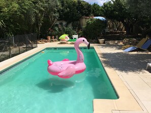 A swimming pool with a pink flamingo float. - Fenced garden with 10x4 pool, 85m2 terrace and shaded terrace (Générac)