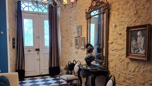 A room with a chandelier, a patterned rug, a checkered floor, and a large mirror on the wall. - an unusual and Design Chateau (Pech- Luna)