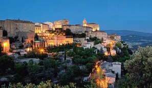 A historic town with stone buildings and a prominent castle-like structure. - Charming old farmhouse with swimming pool between Luberon and Alpille (Cavaillon)
