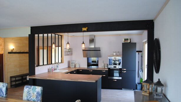 A modern kitchen with a central island, built-in appliances, and a dining area with patterned chairs. - Detached house 3 Bedrooms, 140 M2, Loggia, Balcony, private garden 800 M2 (Les Hôpitaux-Neufs)