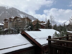 A snow-covered mountain resort with wooden buildings and a wooden deck.