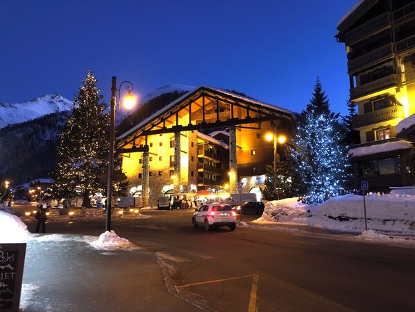 A hotel with a stone facade, large windows, and a balcony overlooking a snowy mountain. - Rent studio prestige center station ideal couple and 2 children (Val-d'Isère)