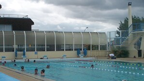 A swimming pool with lanes, a diving platform, and a covered spectator area. -  STUDIO SEASIDE 30 METERS FROM THE EXPOSURE DUE SOUTH BEACH  (Courseulles-Sur-Mer)