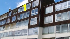 A multi-story building with numbered windows indicating different sections. -  STUDIO SEASIDE 30 METERS FROM THE EXPOSURE DUE SOUTH BEACH  (Courseulles-Sur-Mer)