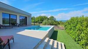 A modern house with a swimming pool, outdoor seating, and a well-maintained garden. - Stylish villa *****, heated pool (Rakalj)
