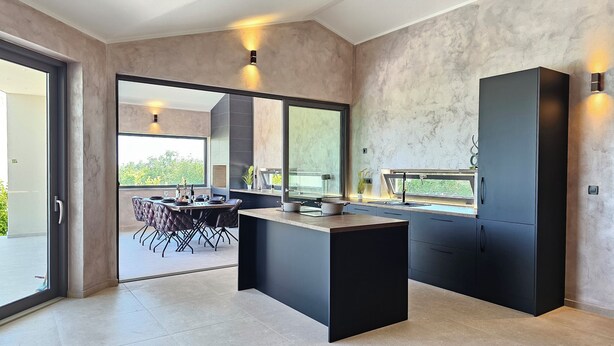 A modern kitchen with a large island, dark cabinetry, and a view of the outdoors. - Stylish villa *****, heated pool (Rakalj)