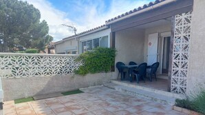 A patio area with a tiled floor, a white decorative fence, and a table with chairs. - .Maison Quiet, sunny position good in 10 'from the beach residence (Fleury)