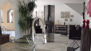 Een moderne keuken met een rvs-spoelbak, een gebogen kraan en een marmeren aanrecht.