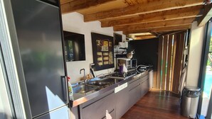 Een moderne keuken met een roestvrijstalen koelkast, houten kastjes en een ingebouwde kookplaat.