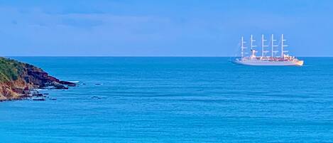 A large ship with multiple sails on the ocean.