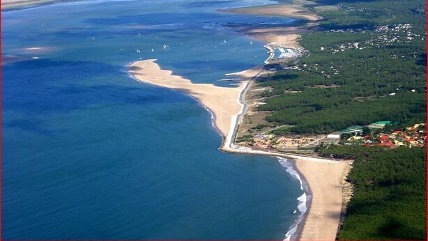 An aerial view of a coastal area with a beach, a lighthouse, and a small settlement with houses. - Charming house near the beach, detached, not overlooked, WIFI. (Arvert)