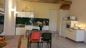 A kitchen with a dining table, chairs, a microwave, and a sink.