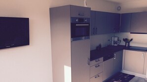Une cuisine compacte équipée d’un four à micro-ondes, d’un four et d’une machine à café.