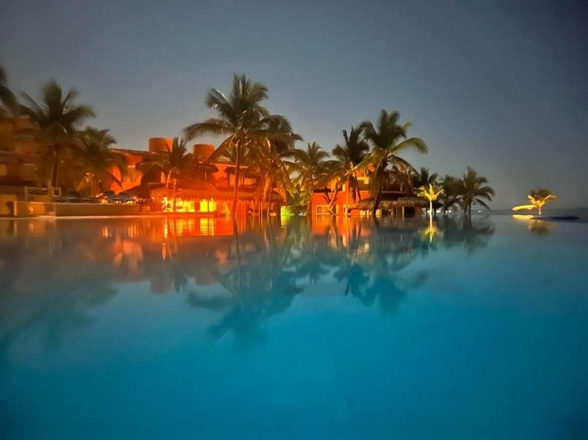 The Villa lit up at night - view from across the pool