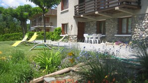 A hotel with a garden, outdoor seating, and a children's play area. - Guillestre ground-floor rental for 2 to 4 people, beautiful south-facing view. (Guillestre)