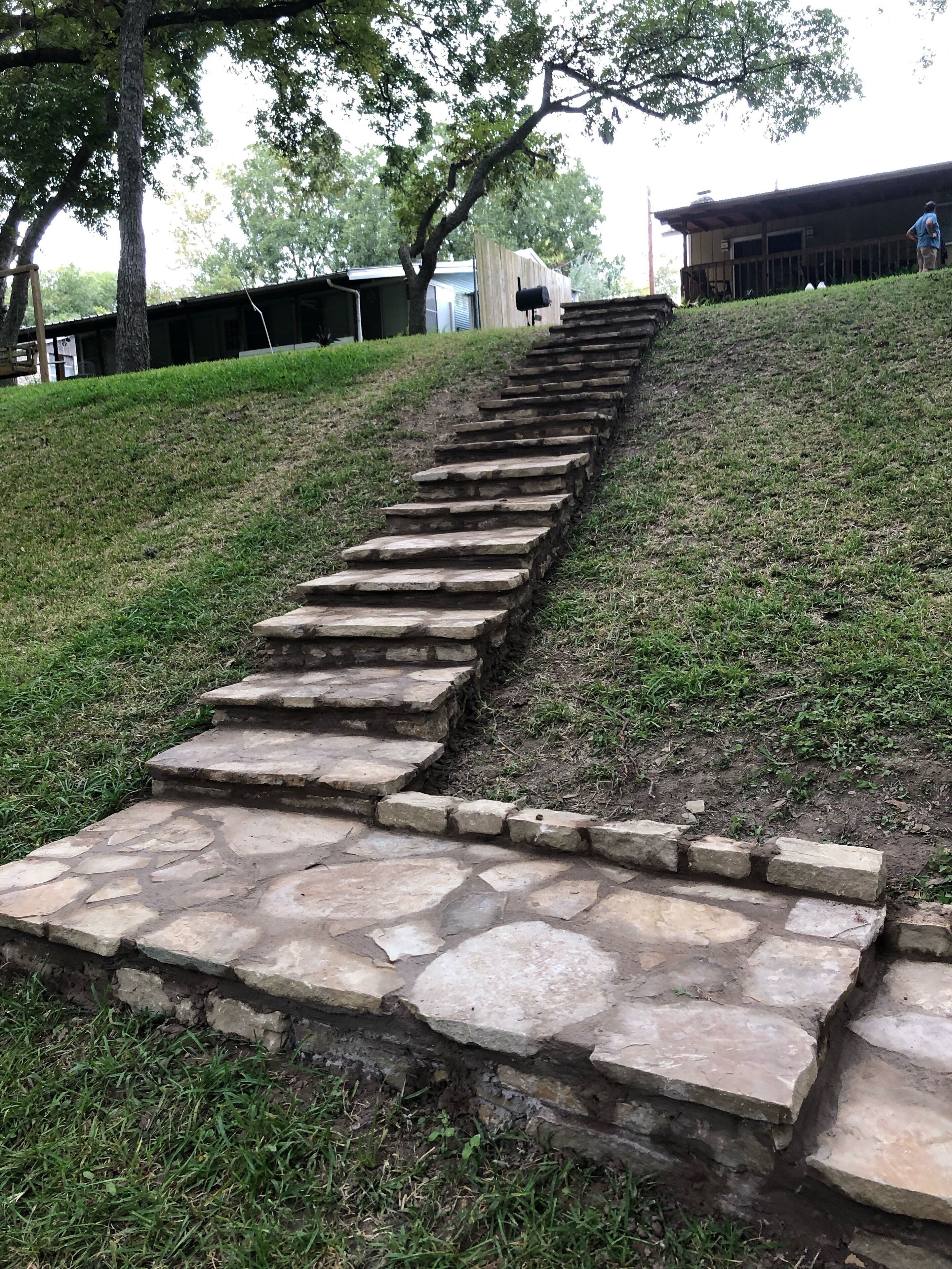 Una escalera de piedra que sube por una colina cubierta de césped.