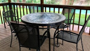 Un espace extérieur abrité, aménagé avec une table ronde et quatre chaises.