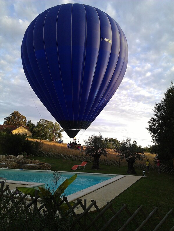 Un globo aerostático con el número de registro F-HFMP volando sobre una zona residencial.