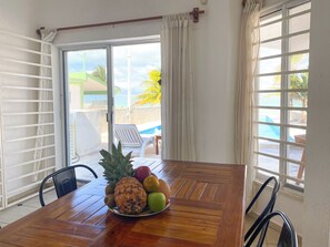 A wooden table with a fruit bowl containing pineapple, apples, and kiwis. - Summer and Fall Dates Available! (Cuburna, Progreso)