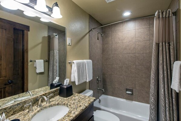 A bathroom with a granite countertop, two sinks, a mirror, a towel rack, a shower, and a bathtub. - Ski-In/Ski-Out Condo at Grand Lodge on Peak 7 – March 7-14, 2026 - 2BD/2BA (Breckenridge)