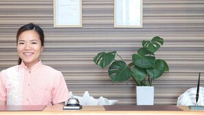Um balcão de recepção com uma planta, certificados emoldurados e um sino.