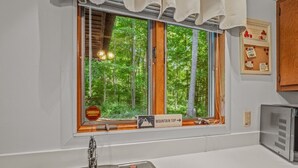 Una cocina con ventana, un fregadero y un refrigerador.