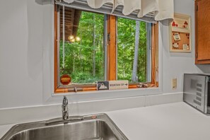 Une cuisine avec une fenêtre, un évier et un réfrigérateur.