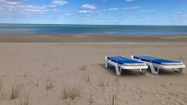Ein Strand mit zwei Liegen und freiem Blick auf das Meer.