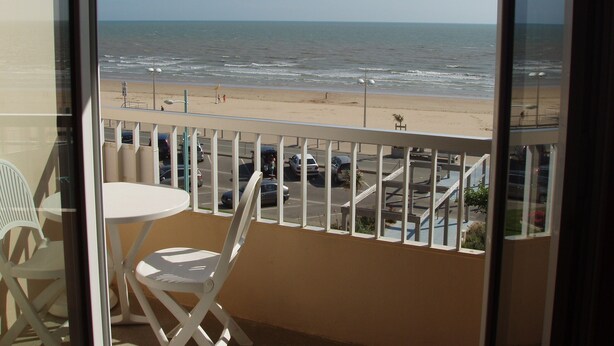 Un balcon avec vue sur la plage et l’océan.