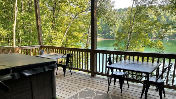 A covered deck with a grill and two tables, overlooking a lake. - Rock of Ages-- Huge Dock w/ 2 Covered Slips & Slide; Great House for Holidays! (LaFollette)
