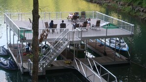A multi-level dock with seating areas and boats. - Rock of Ages-- Huge Dock w/ 2 Covered Slips & Slide; Great House for Holidays! (LaFollette)