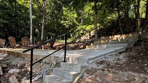 A set of concrete steps with a metal handrail, surrounded by trees and natural debris. - Rock of Ages-- Huge Dock w/ 2 Covered Slips & Slide; Great House for Holidays! (LaFollette)