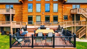 Eine Blockhütte mit einer Veranda, Sitzgelegenheiten im Freien und einer Treppe.