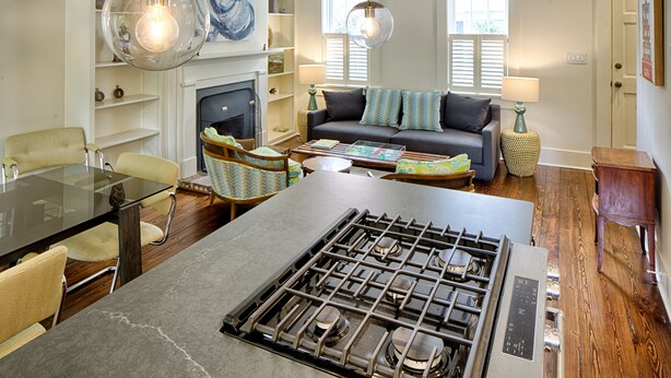 Ein modernes Wohnzimmer mit Kamin, Essbereich und Küche inklusive Gasherd.