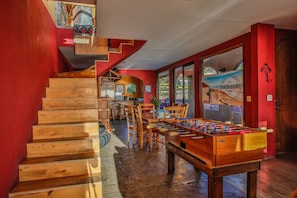 Enjoy a beachside retreat with a foosball table and staircase leading to a cozy upper level.