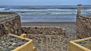 Un sentiero in pietra conduce a una spiaggia con vista sull'oceano.