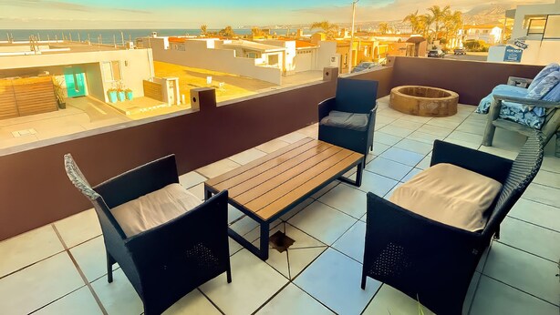 Una terrazza sul tetto con tavolo, sedie e vista sulla città.
