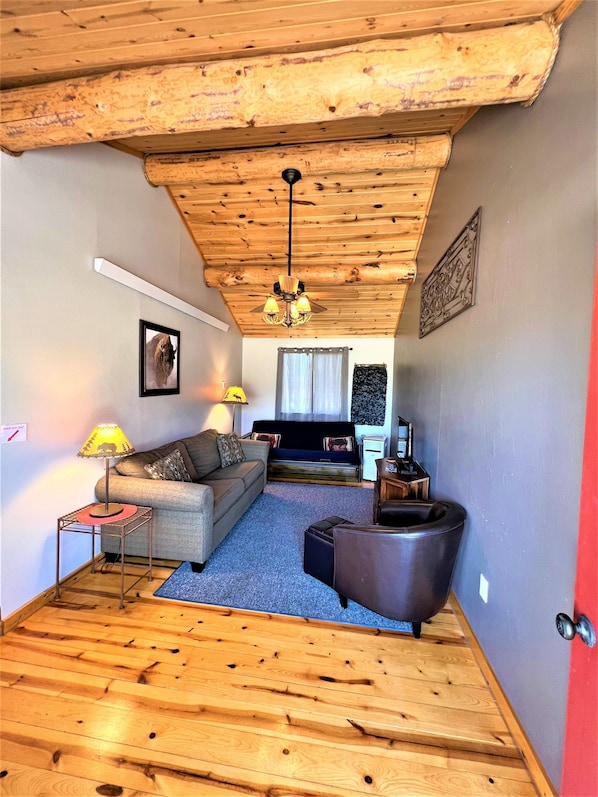 A cozy living room with a wooden ceiling, a sofa, a coffee table, and a fireplace. - #5 Buffalo Cabin at Ponderosa Place (Custer)