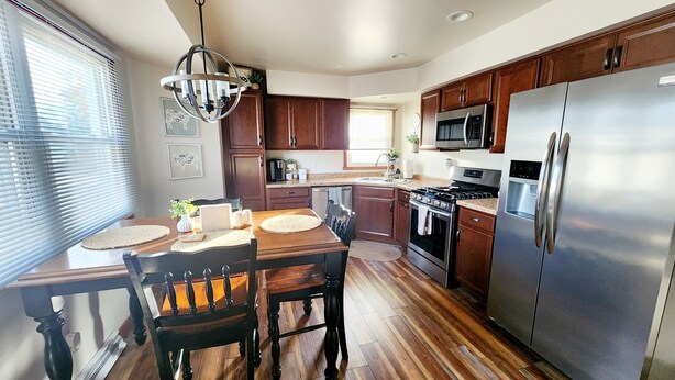 A modern kitchen with wooden cabinets, stainless steel appliances, and a dining area with a wooden table and chairs. - Great for EAA rental!
Less than 2.5 miles from EAA grounds! (Oshkosh)