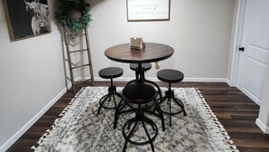 A dining area with a round table, four chairs, a decorative rug, a framed sign, and a wall-mounted plant. - Great for EAA rental!
Less than 2.5 miles from EAA grounds! (Oshkosh)