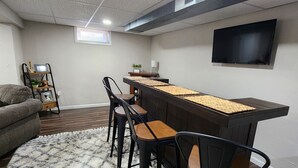 A modern living room with a bar area, a gray couch, and a patterned rug. - Great for EAA rental!
Less than 2.5 miles from EAA grounds! (Oshkosh)